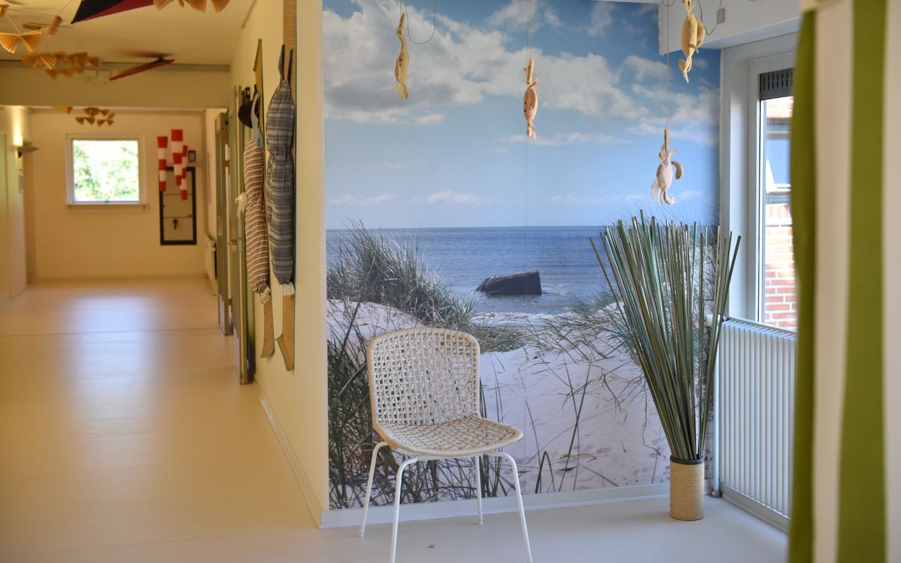 Fællesområde med stol og vægmaleri på Rosenvænget