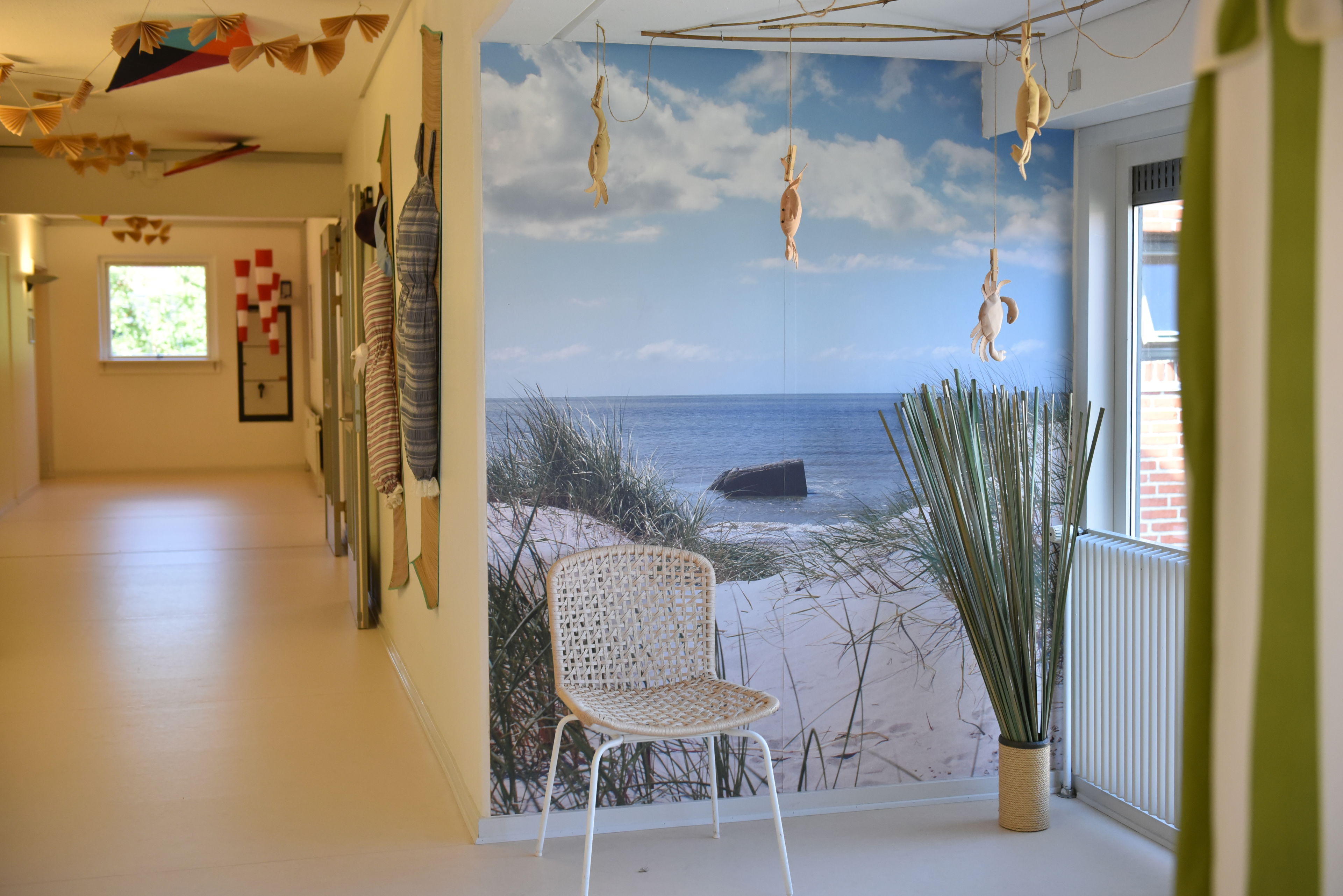 Fællesområde med stol og vægmaleri på Rosenvænget